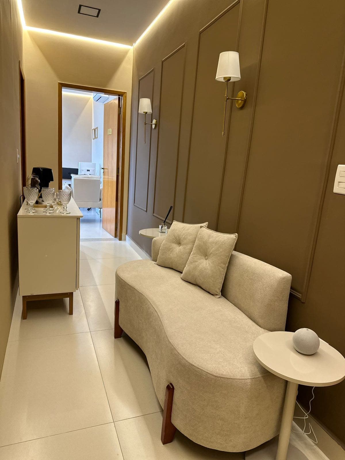 Sala de espera da clínica com sofá e iluminação aconchegante